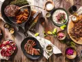 Ein Sommelier wählt den perfekten Wein zu saftigen Steaks, Beilagen und frischen Salaten.