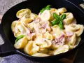 Köstliche Tortellini in cremiger Sauce mit Schinken und frischem Basilikum. Ein einfaches Gericht, das zu den beliebtesten Tortellini Rezepten zählt.