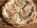 Frisch gebackener Pizzateig mit Mortadella und Pistazien. Ein Genuss, der das Pizzabacken zu einem Erlebnis macht.