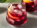 Erfrischender Rotwein im Sommer, serviert mit Eis und Zitronenscheiben. Perfekt für heiße Tage!
