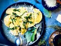 Frische Ravioli, ein italienisches Gericht, mit geriebenem Parmesan und Kräutern garniert. Das Ravioli-Teig Rezept italienisch ist hier perfekt umgesetzt.