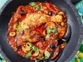 Herzhaftes Pollo Cacciatore in Tomatensauce mit Oliven, Kapern und Pilzen, garniert mit frischen Kräutern.