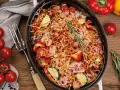 Herzhaftes Spaghetti al Forno mit Tomaten, Zucchini und Paprika, überbacken mit Käse und garniert mit Rosmarin.