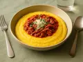 Herzhafte Polenta Taragna mit deftigem Ragout und Parmesan. Ein Genuss für jeden Gaumen.