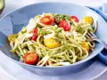 Spaghetti mit cremigem Avocado Pesto, Kirschtomaten und Parmesan.