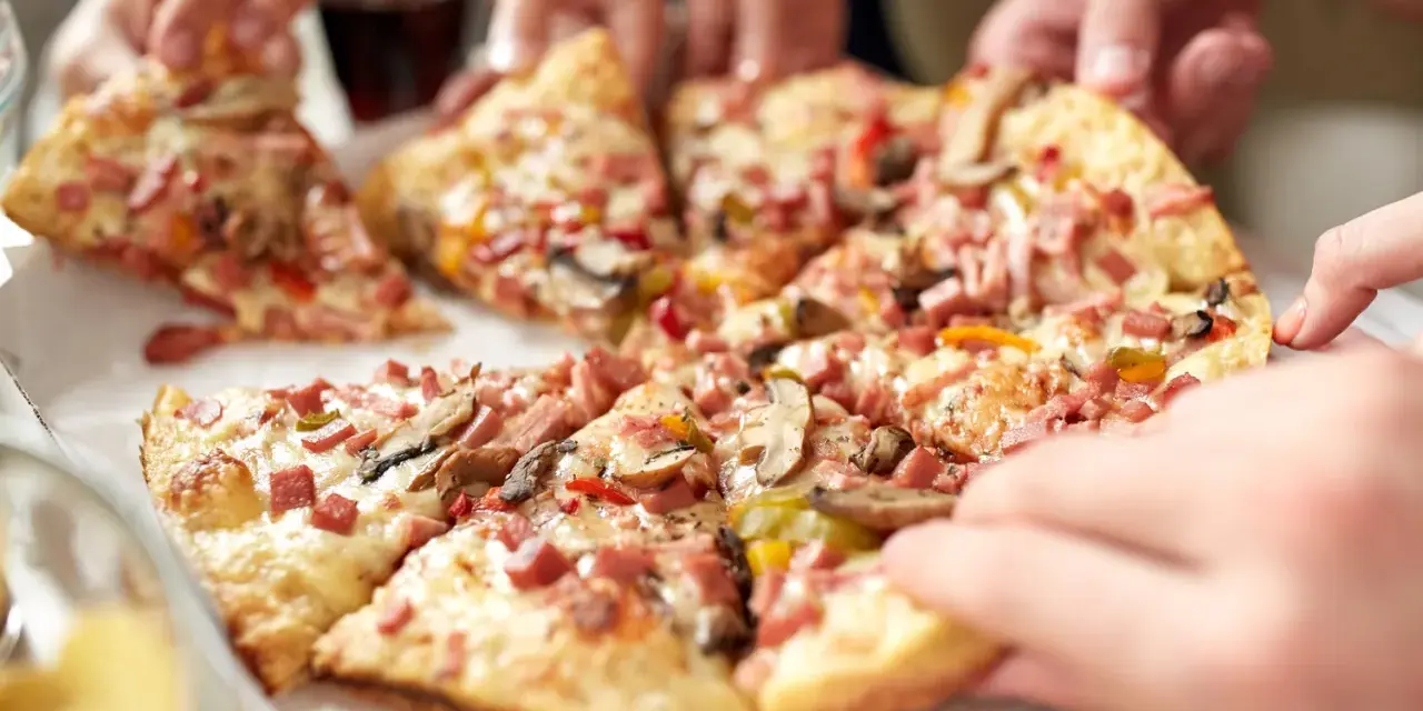 Hände greifen nach leckeren Stücken einer glutenfreien Pizza. Ein tolles glutenfreies Pizza Rezept für alle!
