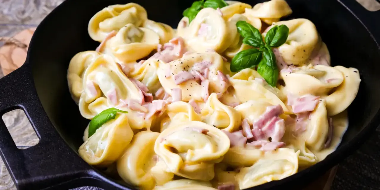 Köstliche Tortellini in cremiger Sauce mit Schinken und frischem Basilikum. Ein einfaches Gericht, das zu den beliebtesten Tortellini Rezepten zählt.