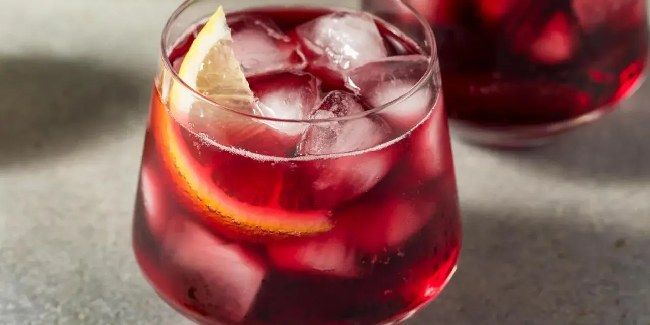 Erfrischender Rotwein im Sommer, serviert mit Eis und Zitronenscheiben. Perfekt für heiße Tage!