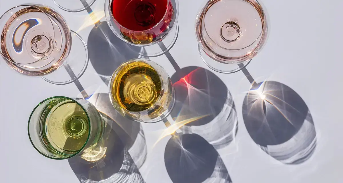 Fünf Gläser Wein in verschiedenen Farben, darunter Rot, Rosé und Weiß. Die Frage: ist alkoholfreier Wein wirklich alkoholfrei?