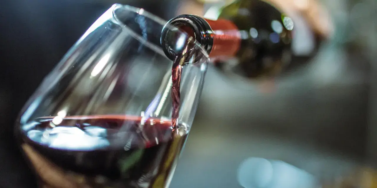 Rotwein fließt ins Glas. Ein Schluck für die Gesundheit und den Genuss.