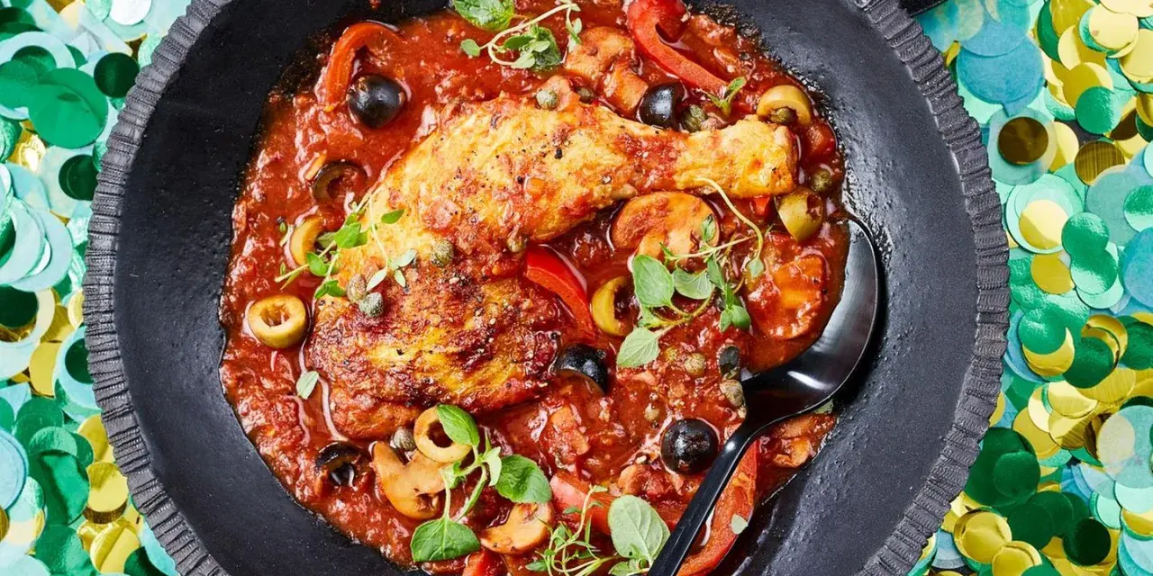 Herzhaftes Pollo Cacciatore in Tomatensauce mit Oliven, Kapern und Pilzen, garniert mit frischen Kräutern.