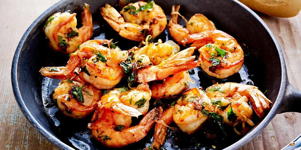 Saftige Garnelen in Knoblauchöl, ein Klassiker der italienischen scampi rezepte. Dazu Baguette.