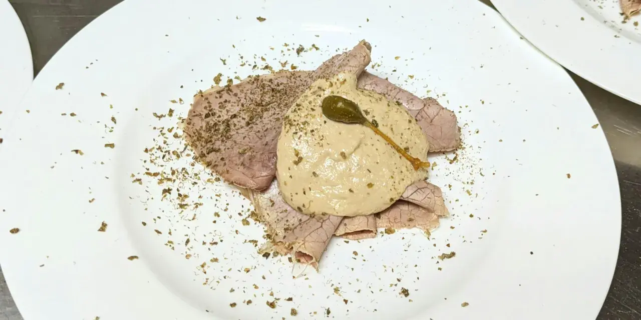 Dünne Scheiben Braten mit einer cremigen thunfischsauce italienisch, garniert mit Kapern und Kräutern.
