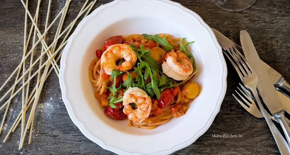 Ein köstliches garnelen italienisch rezept: Spaghetti mit Garnelen, Kirschtomaten und Rucola in einer cremigen Sauce.