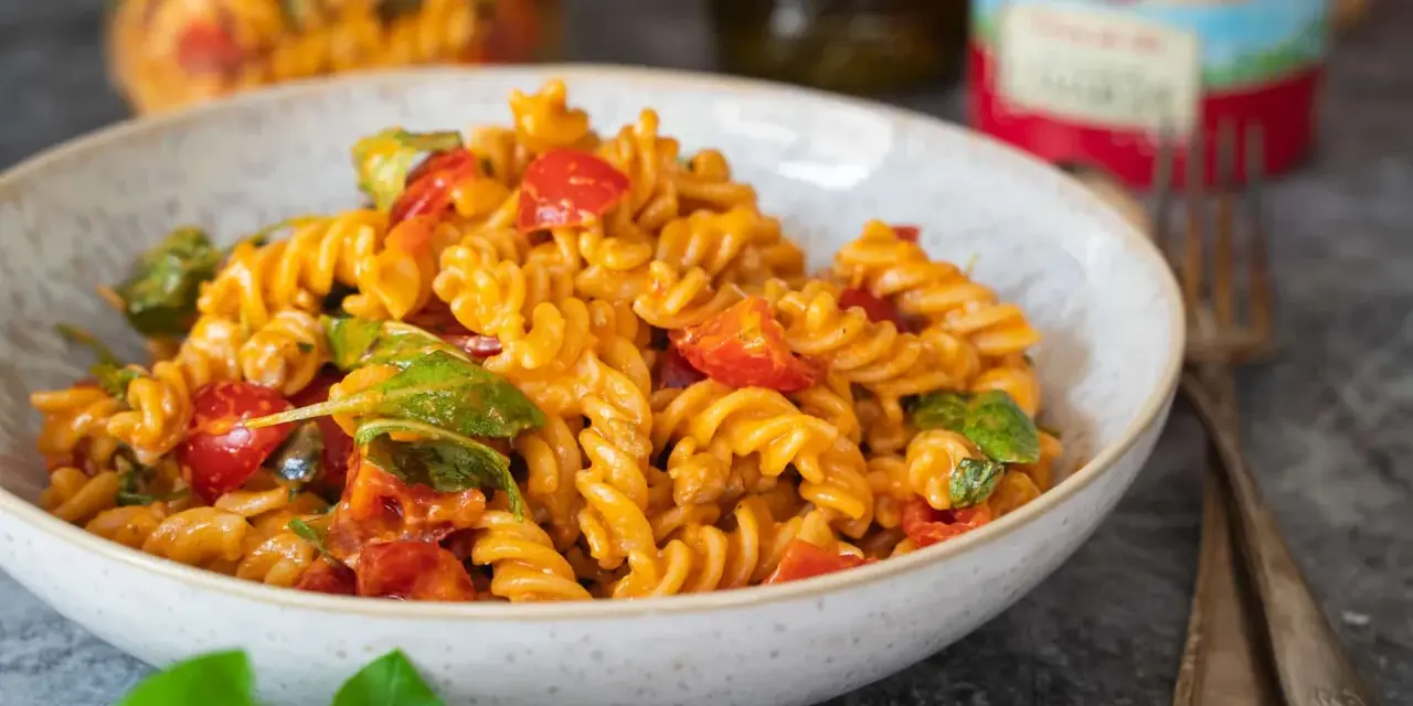 Fusilli-Nudeln mit Kirschtomaten und Basilikum in einer cremigen Sauce, die nach salat mit pesto schmeckt.