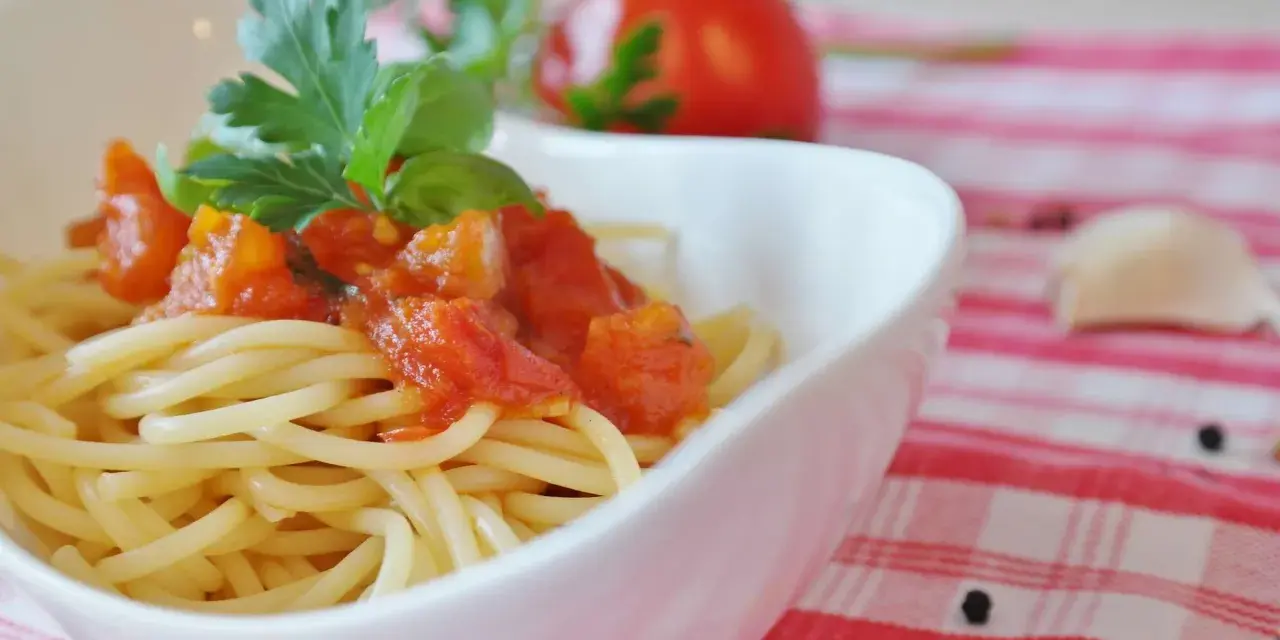 Spaghetti mit einem frischen Sugo di Pomodoro, garniert mit Basilikum und Petersilie. Ein Hauch von Italien auf dem Teller.
