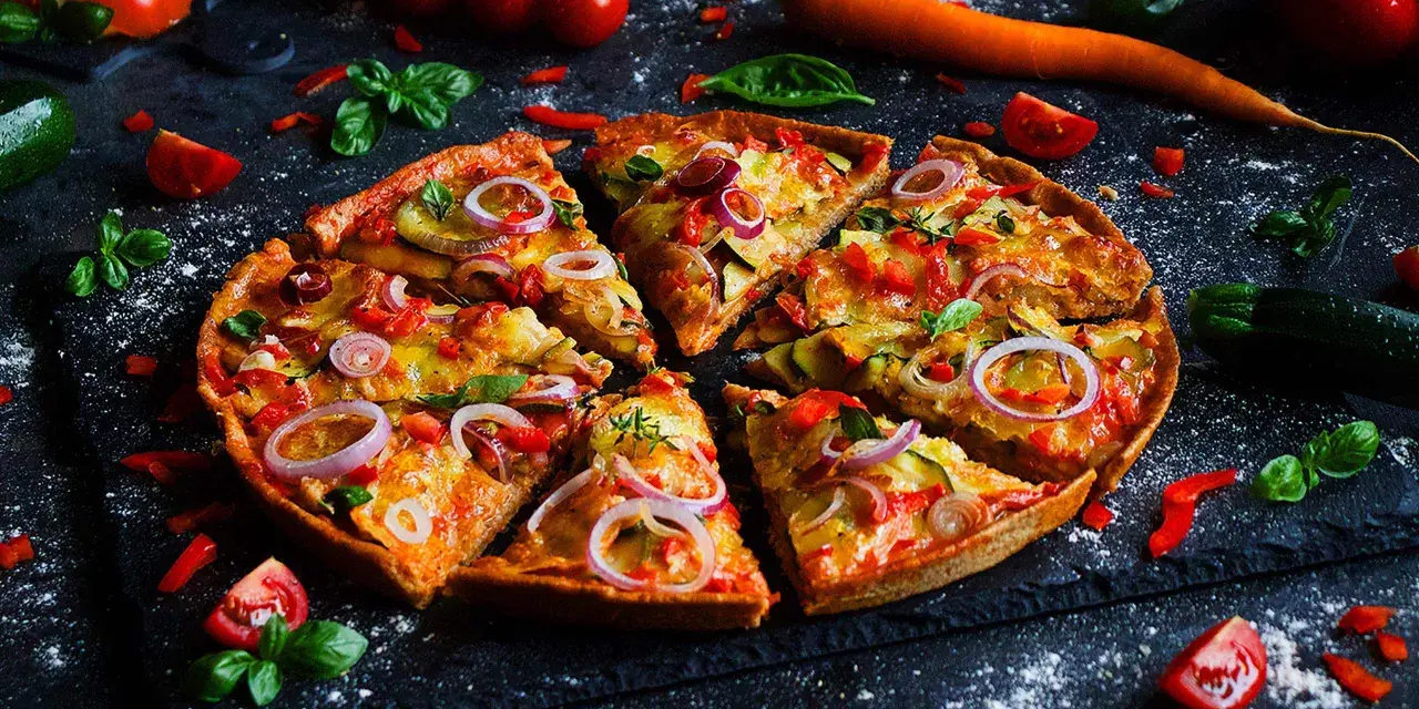 Leckere Pizza mit Gemüse, perfekt für ein Pizza backen Rezept. Frische Tomaten, Zucchini und rote Zwiebeln machen sie unwiderstehlich.
