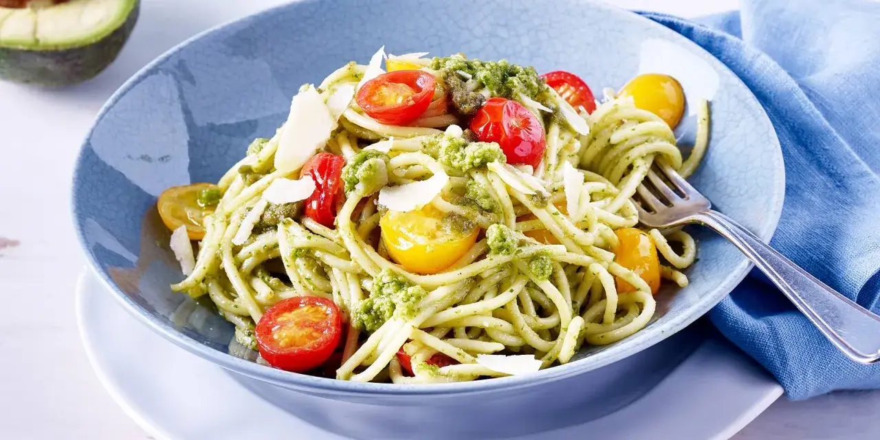 Spaghetti mit cremigem Avocado Pesto, Kirschtomaten und Parmesan.