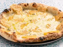 Eine köstliche Pizza Formaggi mit geschmolzenem Käse und knusprigem Rand, serviert auf einem Teller mit blau-weißem Muster.