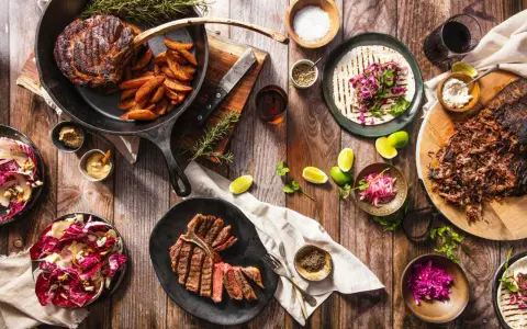 Ein Sommelier wählt den perfekten Wein zu saftigen Steaks, Beilagen und frischen Salaten.