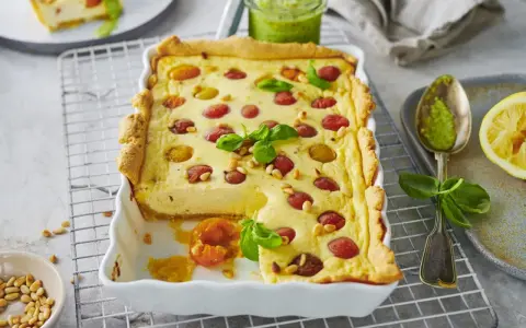 Herzhafte Ricotta-Tarte mit Kirschtomaten und Pinienkernen. Ein köstliches Beispiel für italienische Ricotta Rezepte, serviert mit Pesto.