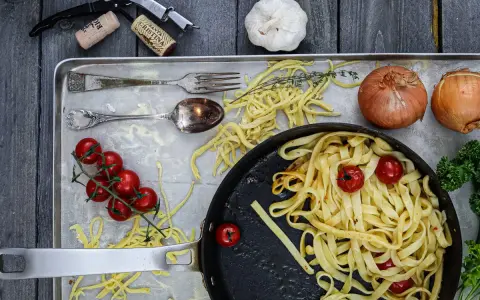 Frische Nudeln aus Hartweizengries, Tomaten, Zwiebeln und Knoblauch auf einem Blech. Ein Festmahl für Genießer!