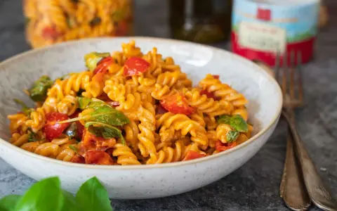 Fusilli-Nudeln mit Kirschtomaten und Basilikum in einer cremigen Sauce, die nach salat mit pesto schmeckt.