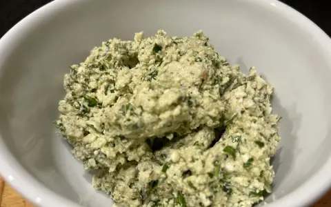 Ein cremiger Käseaufstrich mit Kräutern, wie er für ein Moretum Rezept typisch ist.