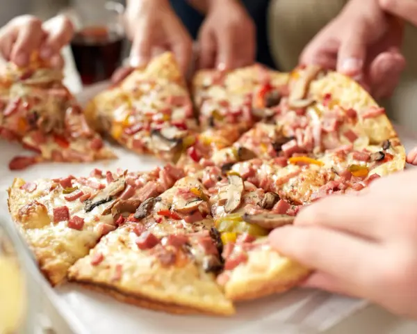 Hände greifen nach leckeren Stücken einer glutenfreien Pizza. Ein tolles glutenfreies Pizza Rezept für alle!