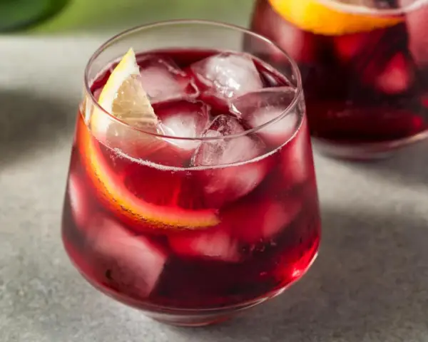 Erfrischender Rotwein im Sommer, serviert mit Eis und Zitronenscheiben. Perfekt für heiße Tage!