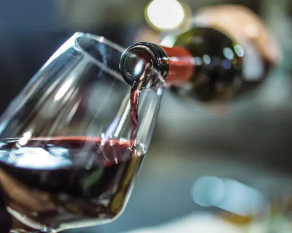 Rotwein fließt ins Glas. Ein Schluck für die Gesundheit und den Genuss.