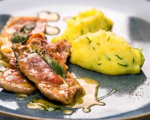 Saltimbocca Rezepte Italienisch: Zarte Kalbsschnitzel mit Salbei und Schinken, serviert mit cremigem Kartoffelpüree.