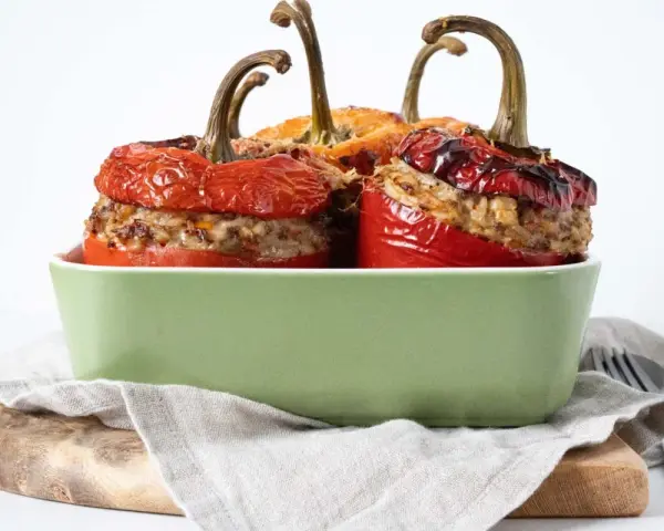 Saftige peperoni ripieni, gefüllt mit Hackfleisch und Reis, in einer grünen Auflaufform.