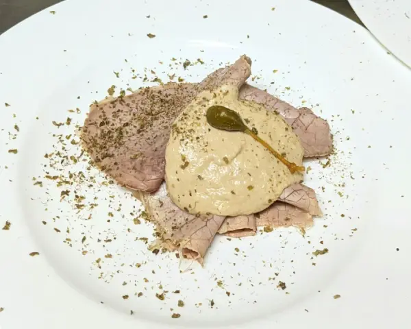 Dünne Scheiben Braten mit einer cremigen thunfischsauce italienisch, garniert mit Kapern und Kräutern.