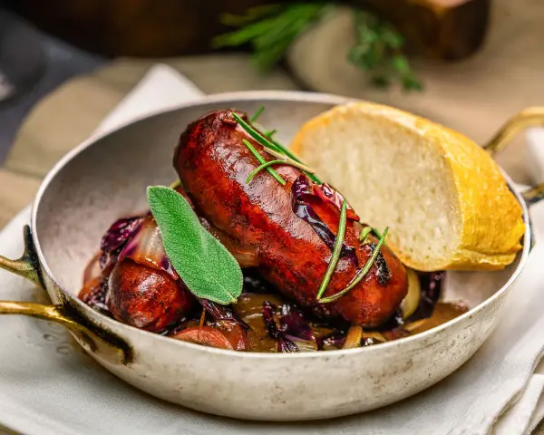 Herzhafte italienische Bratwurst Salsiccia mit Rotkohl und Brot. Ein köstliches Rezept für Salsiccia.