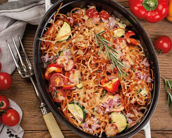 Herzhaftes Spaghetti al Forno mit Tomaten, Zucchini und Paprika, überbacken mit Käse und garniert mit Rosmarin.