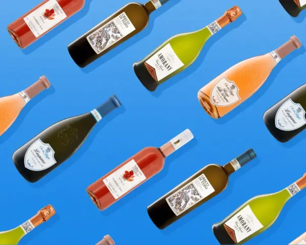 Flaschen mit verschiedenen Weinen, darunter Rosé und Weißwein, sind auf blauem Hintergrund angeordnet. Ein Hauch von Venetien Wein in jeder Flasche.