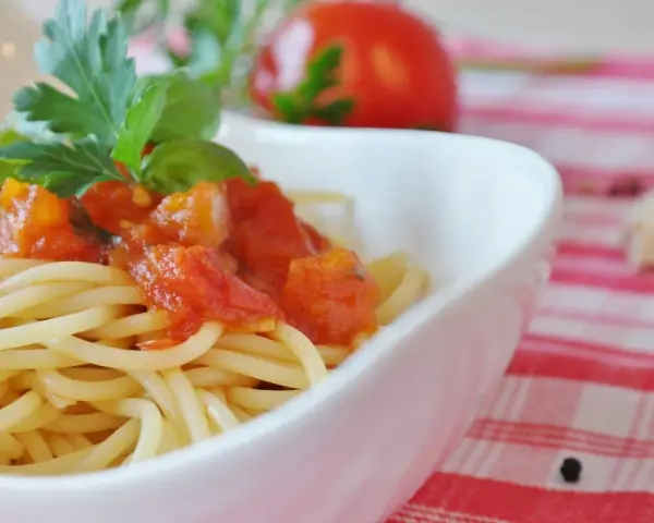 Spaghetti mit einem frischen Sugo di Pomodoro, garniert mit Basilikum und Petersilie. Ein Hauch von Italien auf dem Teller.