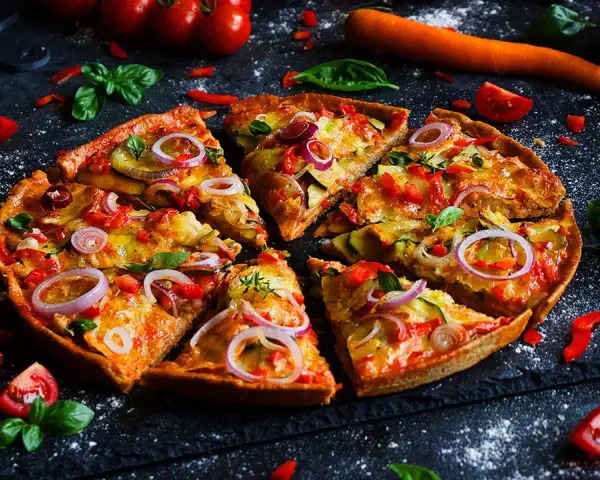 Leckere Pizza mit Gemüse, perfekt für ein Pizza backen Rezept. Frische Tomaten, Zucchini und rote Zwiebeln machen sie unwiderstehlich.