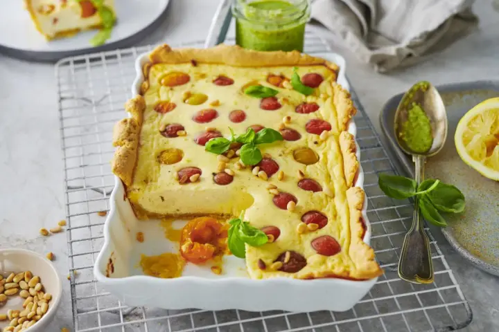 Herzhafte Ricotta-Tarte mit Kirschtomaten und Pinienkernen. Ein köstliches Beispiel für italienische Ricotta Rezepte, serviert mit Pesto.