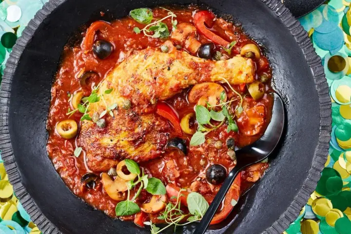Herzhaftes Pollo Cacciatore in Tomatensauce mit Oliven, Kapern und Pilzen, garniert mit frischen Kräutern.