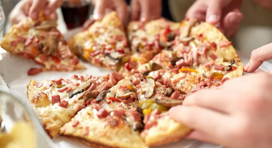 Hände greifen nach leckeren Stücken einer glutenfreien Pizza. Ein tolles glutenfreies Pizza Rezept für alle!