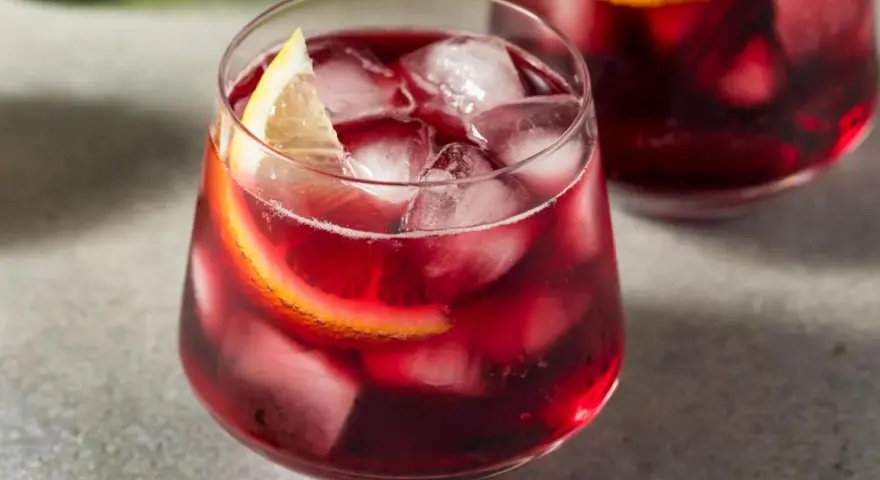 Erfrischender Rotwein im Sommer, serviert mit Eis und Zitronenscheiben. Perfekt für heiße Tage!