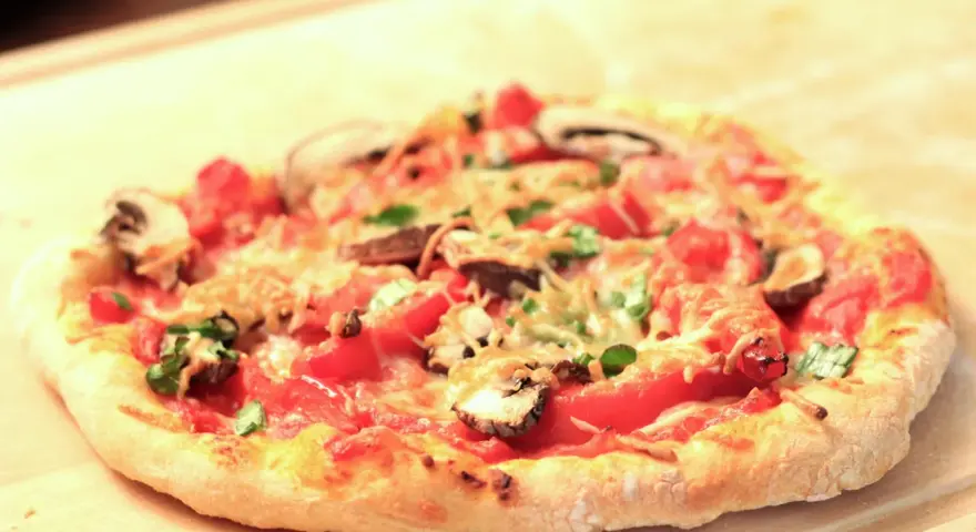Eine köstliche Pizza mit Pilzen und Tomaten auf einem luftigen pizzateig mit lievito madre, bereit zum Genießen.