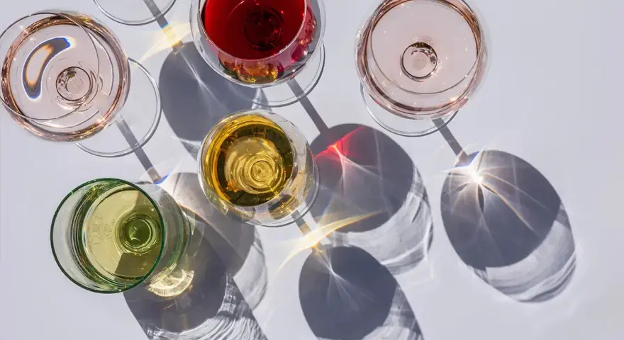 Fünf Gläser Wein in verschiedenen Farben, darunter Rot, Rosé und Weiß. Die Frage: ist alkoholfreier Wein wirklich alkoholfrei?