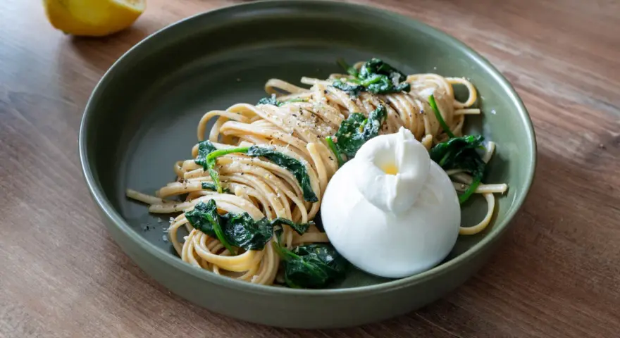 Pasta mit Spinat und einer cremigen Burrata, garniert mit frisch gemahlenem Pfeffer. Ein Genuss für jeden Tag.