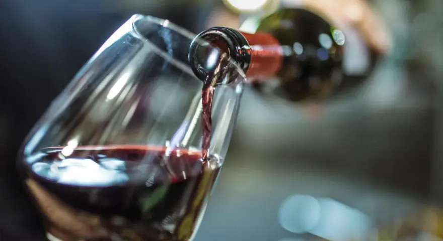 Rotwein fließt ins Glas. Ein Schluck für die Gesundheit und den Genuss.