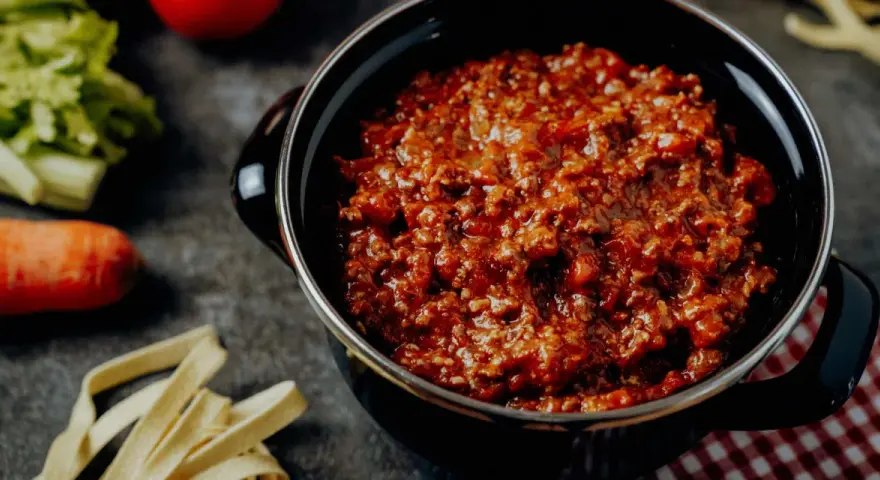 Herzhafte bolognese italienisch Soße in einem Topf, dane frische Pasta, Karotte und Sellerie.