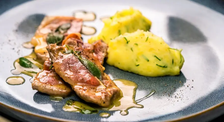 Saltimbocca Rezepte Italienisch: Zarte Kalbsschnitzel mit Salbei und Schinken, serviert mit cremigem Kartoffelpüree.
