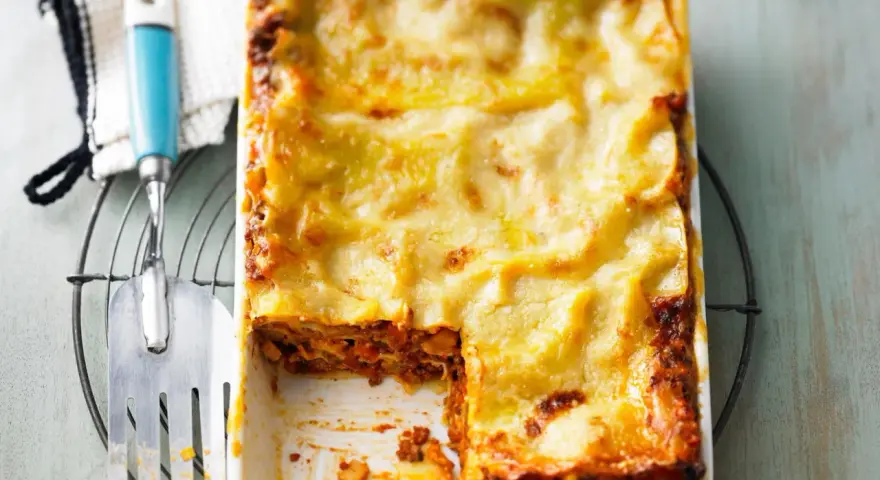 Herzhaftes Lasagne Rezept mit goldbrauner Käsekruste, bereit zum Servieren. Ein Stück fehlt bereits!